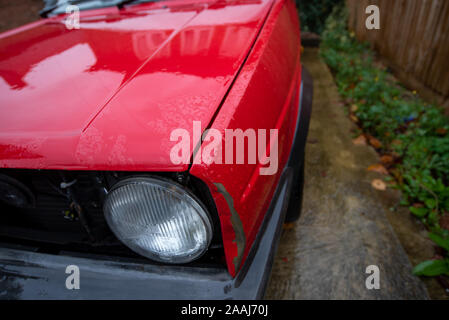 Classic Volkswagen Golf GTI red: Car crash damage and details close up. Crushed metal and plastic. Front bumper damage after a road traffic accident. Stock Photo