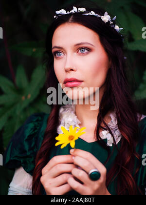 beautiful young woman holding a yellow flower Stock Photo