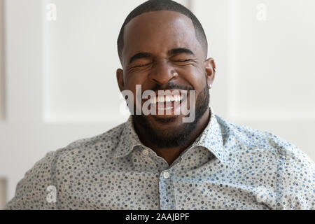 Portrait of excited afrcian American man laughing showing teeth Stock Photo