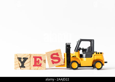 Toy forklift hold wood letter block s to complete word yes on white background Stock Photo