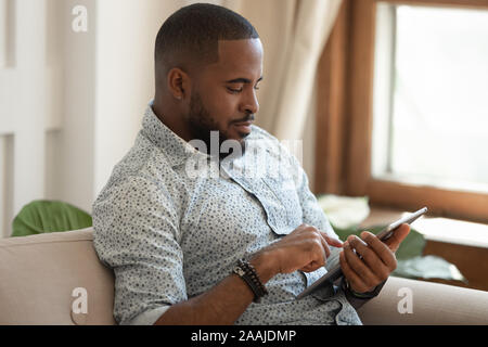African American man rest at home using tablet Stock Photo