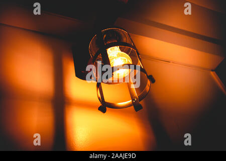 Photo of an incandescent lamp light on in rustic support. Stock Photo