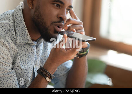 Close up of biracial male using cellphone voice assistant Stock Photo