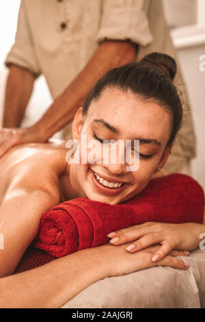 Alternative Medicine. Therapist healing woman smiling happy close-up doing abhyanga back massage with herbal oil Stock Photo