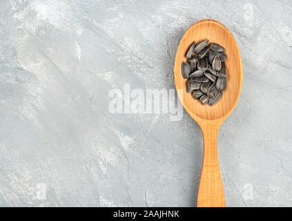 Sunflower seeds in a wooden spoon on an empty concrete background Stock Photo