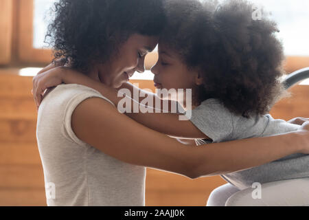 Loving biracial mom and daughter touch foreheads making peace Stock Photo