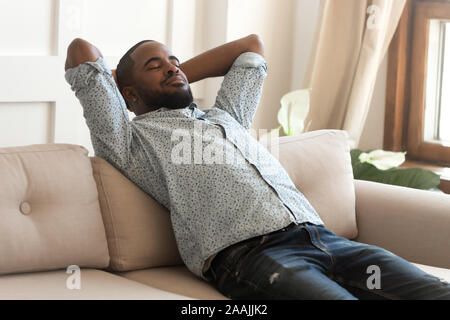 Calm african American relaxing on comfortable sofa at home Stock Photo