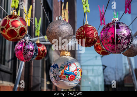 Christmas Balls Ornaments hanging on the clips on the  Clothes Drying Rack. Stock Photo