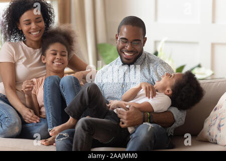 African family with little kids having fun sitting on couch Stock Photo