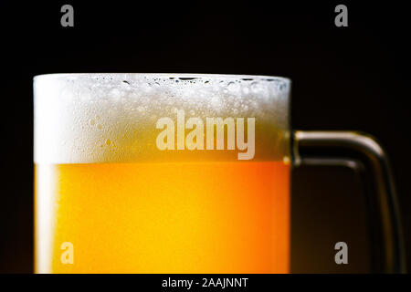 Light Beer Mug with White Foam on Dark Background Close Up Stock Photo