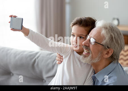 Happy grandfather and little grandchild taking selfie on phone Stock Photo
