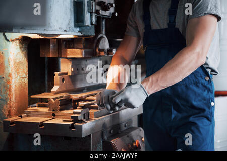 Portrait of a young worker in a hard hat at a large metalworking plant. The engineer serves the machines and manufactures parts for gas equipment Stock Photo