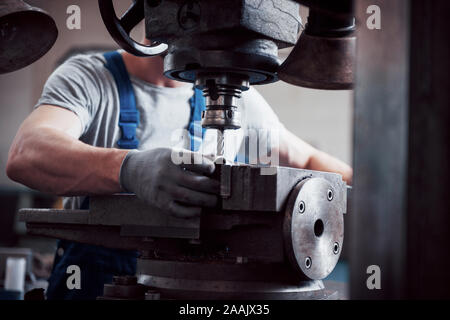 Portrait of a young worker in a hard hat at a large metalworking plant. The engineer serves the machines and manufactures parts for gas equipment Stock Photo