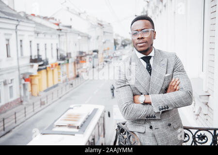 Confident black business man in a stylish suit standing on office block looking at the camera with a serious expression Stock Photo