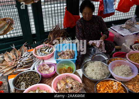 Woman sells dried food at an outdoor market in Tai O, Hong Kong Stock Photo