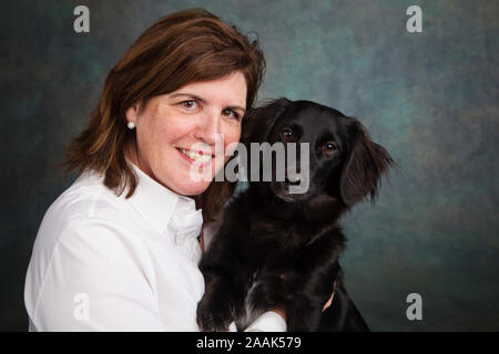 Studio portrait of mature woman with mixed breed dog Stock Photo