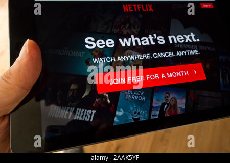 hand holding a tablet with Netflix homepage on the screen Stock Photo