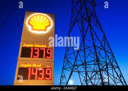 Expensive petrol prices in Billingham on Teeside, UK, with an electricity pylon. This stark image taken at dusk seems to sum up our addiction to energ Stock Photo