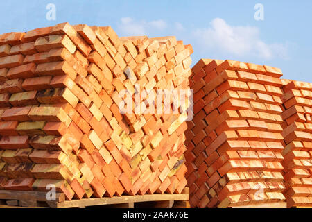 A pile of new bricks at construction site sitting on pallet Stock Photo ...