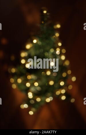 Unfocused fir tree decorated with golden balls on the floor. Stock Photo