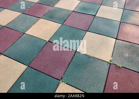 Close up of soft rubber tiles for covering at outdoor gym of stadium at preschool yard.