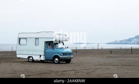 A classic Bedford Camper van parked up on a beach in an English seaside resort. Stock Photo