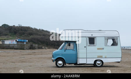 A classic Bedford Camper van parked up on a beach in an English seaside resort. Stock Photo