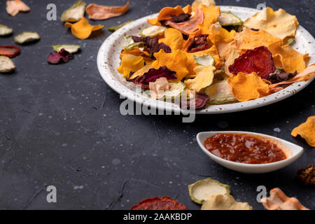 Crisp crunchy organic vegetable chips with dried oven-baked pumpkin, beetroot, squash, tomato, carrot chips snacks Stock Photo