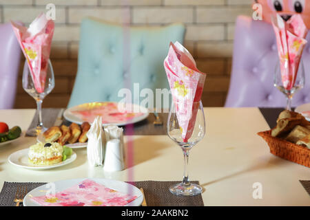 Pink tissue papers in glass .wedding table - decoration with glasses and paper napkin . napkin on the plate . Glass with paper napkins on table Stock Photo