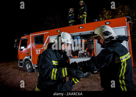 Fire brigade during operation in the field at night time Stock Photo