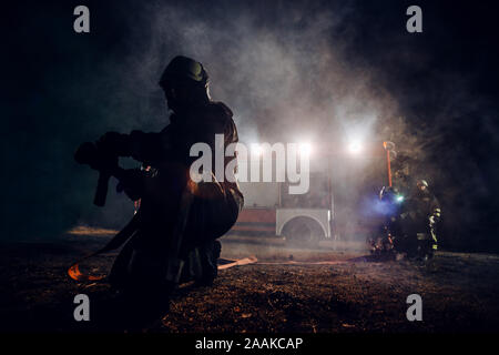 Fire brigade during operation in the field at night time Stock Photo