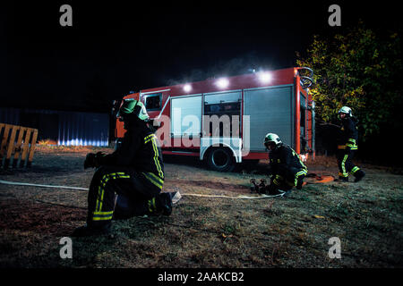 Fire brigade during operation in the field at night time Stock Photo