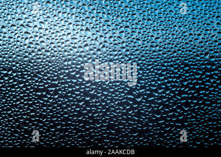 drops of rain water water on a blue glass surface Stock Photo