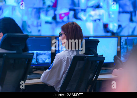 In the System Control Room, Technical Operator Works at His Workstation with Multiple Displays, Security guard working on multiple monitors. Stock Photo