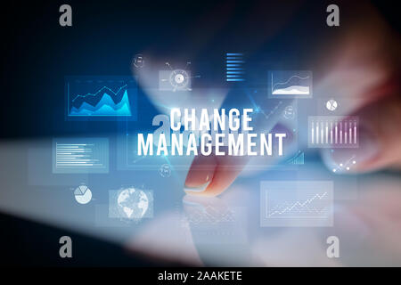 Finger touching tablet with charts and CHANGE MANAGEMENT inscription, business concept Stock Photo