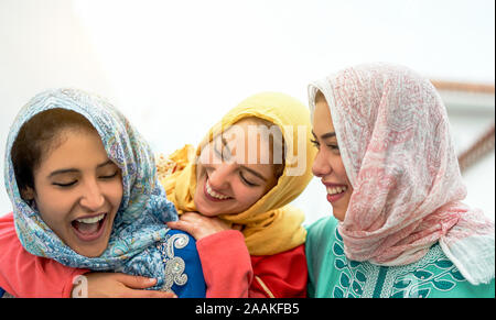 Happy arabian women having fun in the city - Young muslim girls spending time and laughing together outdoor Stock Photo