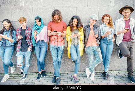 Group of fashion friends watching on their smart mobile phones - Millennial generation z addicted to new technology trends Stock Photo