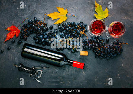 Download Composition of a bottle of wine, two glasses and a gift box with a red bow on a dark background ...