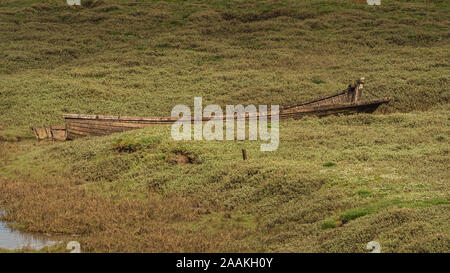 The wreck of a boat in the grass, seen in Askam-in-Furness, Cumbria, England, UK Stock Photo