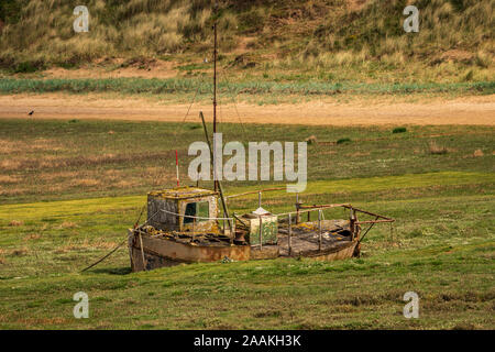 The wreck of a boat in the grass, seen in Askam-in-Furness, Cumbria, England, UK Stock Photo