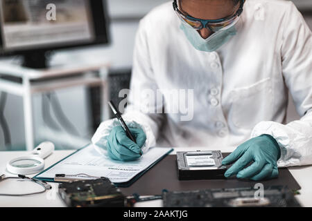 Forensic science investigator examining computer hard drive. Digital forensic science concept. Stock Photo