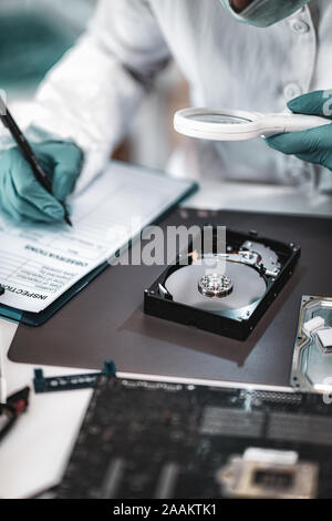 Forensic science investigator examining computer hard drive. Digital forensic science concept. Stock Photo