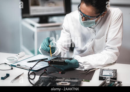 Forensic science investigator examining computer hard drive. Digital forensic science concept. Stock Photo