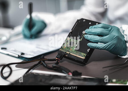 Forensic science investigator examining computer hard drive. Digital forensic science concept. Stock Photo