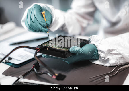 Forensic science investigator examining computer hard drive. Digital forensic science concept. Stock Photo