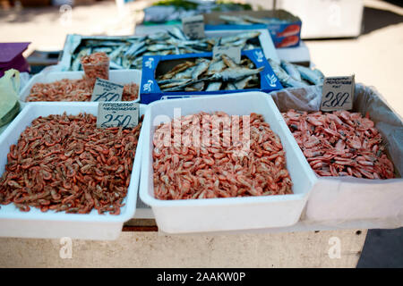 Dried fish and grilled boiled shrimp on stall on summer market for sale. Salted local seafood. Fishing concept. Stock Photo