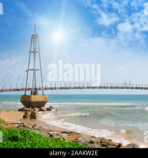 The bridge to the island, the ocean and the sun in the blue sky (Matara, Sri Lanka) Stock Photo
