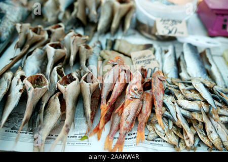 Dried fish on rope at stall on summer market for sale. Salted local seafood. Fishing concept. Stock Photo