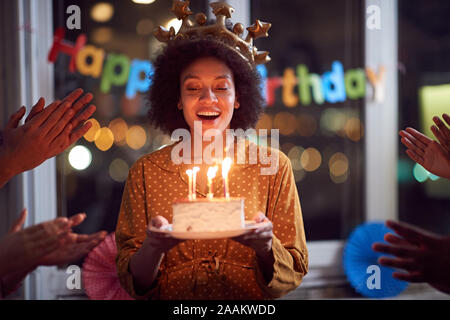 Happy woman blowing out her birthday candles and celebrating Birthday Stock Photo