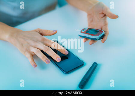 Mobile health. Measuring glucose levels and using smart phone. Stock Photo